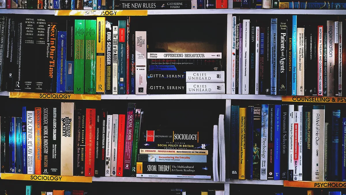 A bookshelf with multiple books, including some with titles visible, arranged in a neat and organized manner.